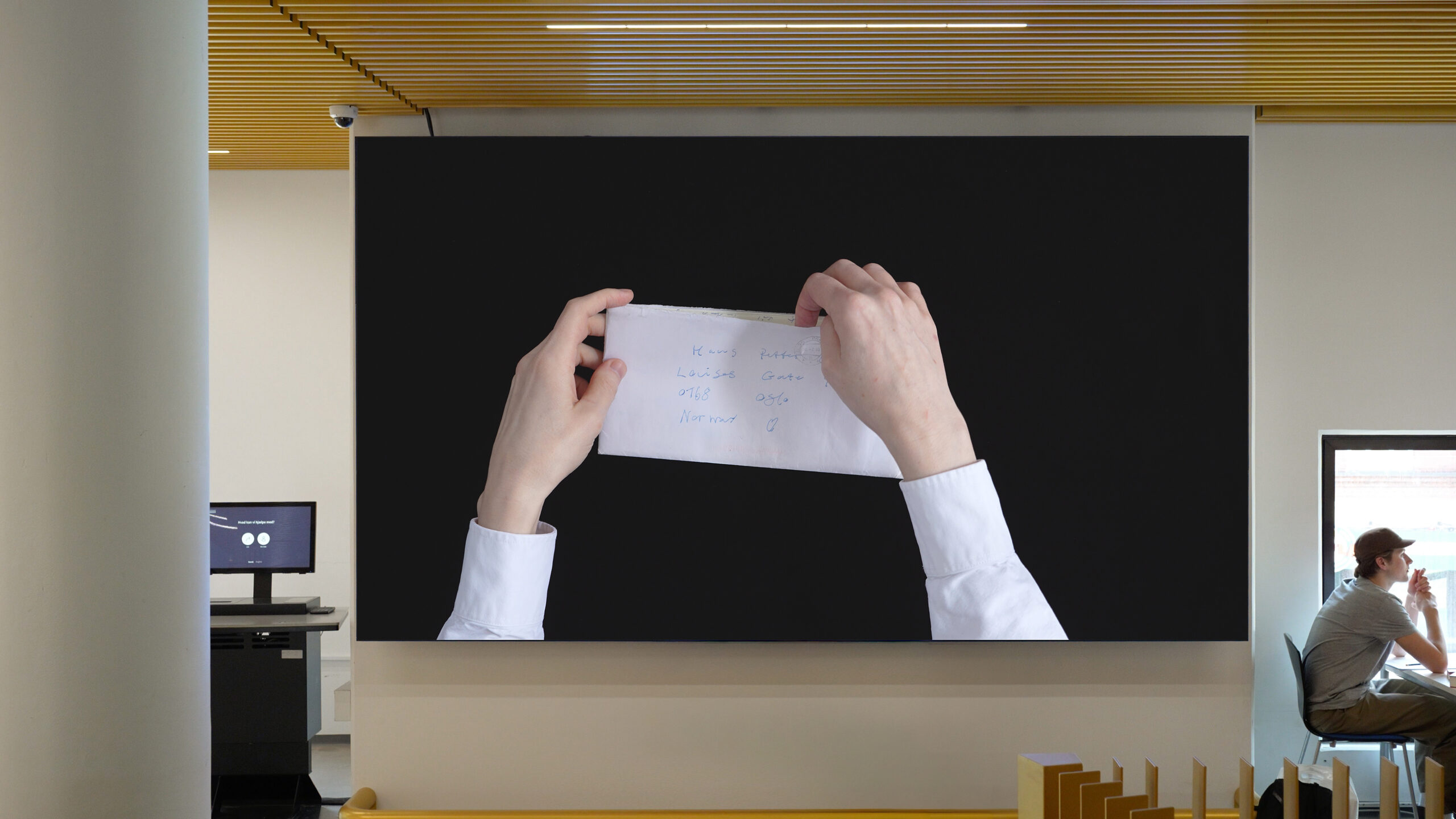 Displayed on the library's widescreen is a video work; this photo shows an element of it.